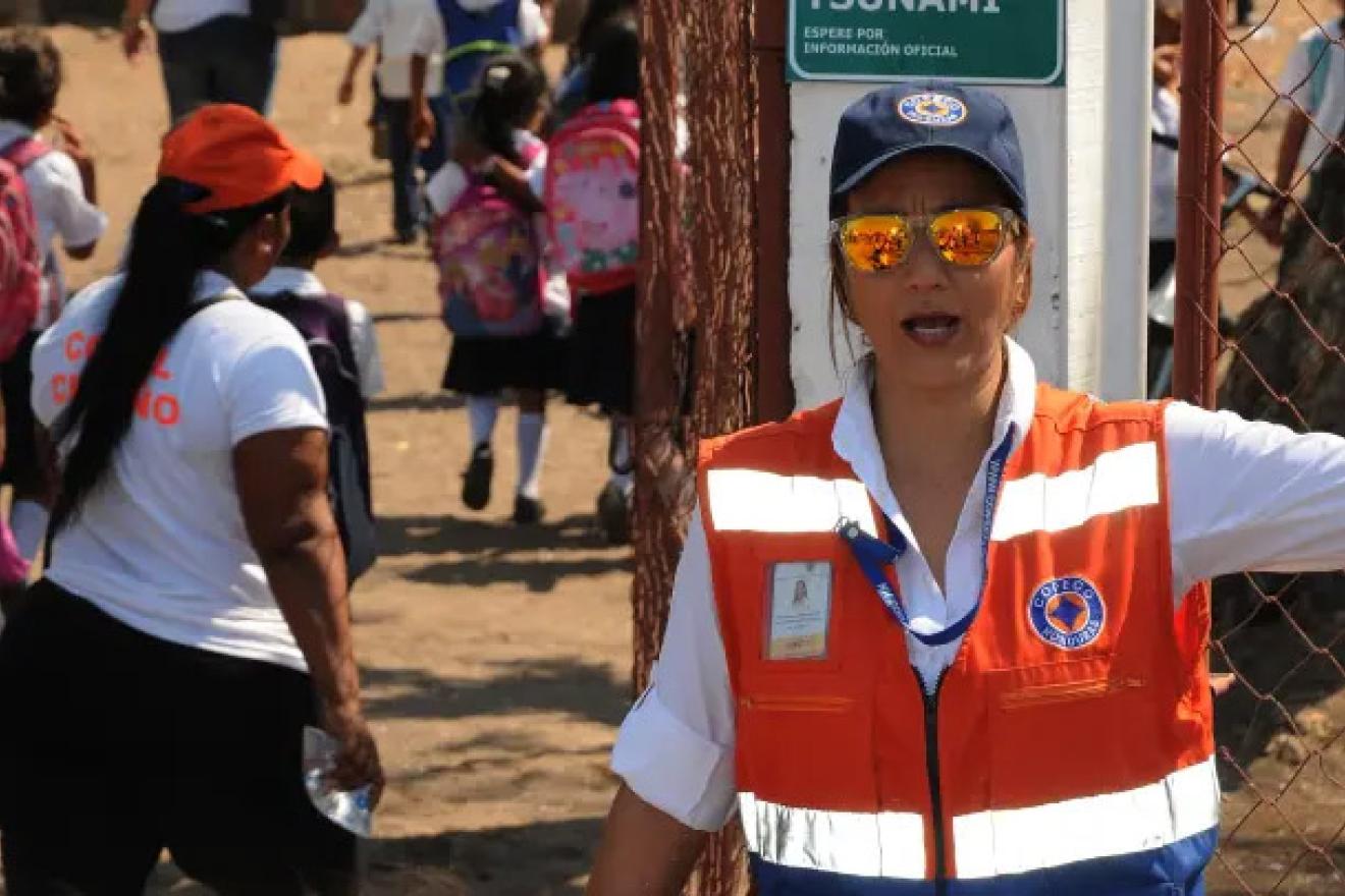 Une femme en gilet de sécurité dirige la foule