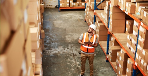 Nationwide network employee cataloging packages in warehouse.