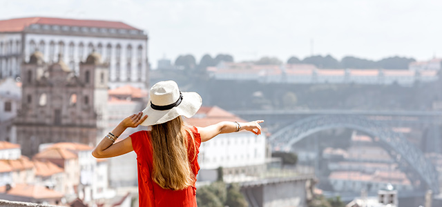 Mulher de vestido vermelho a olhar para Lisboa